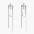 White gold plated baroque cross stud earrings with long cascading zirconia chains on cream background