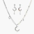 Mixed-metal jewelry set featuring layered necklaces with crescent moon pendant and pearl beads, plus matching star-drop earrings.