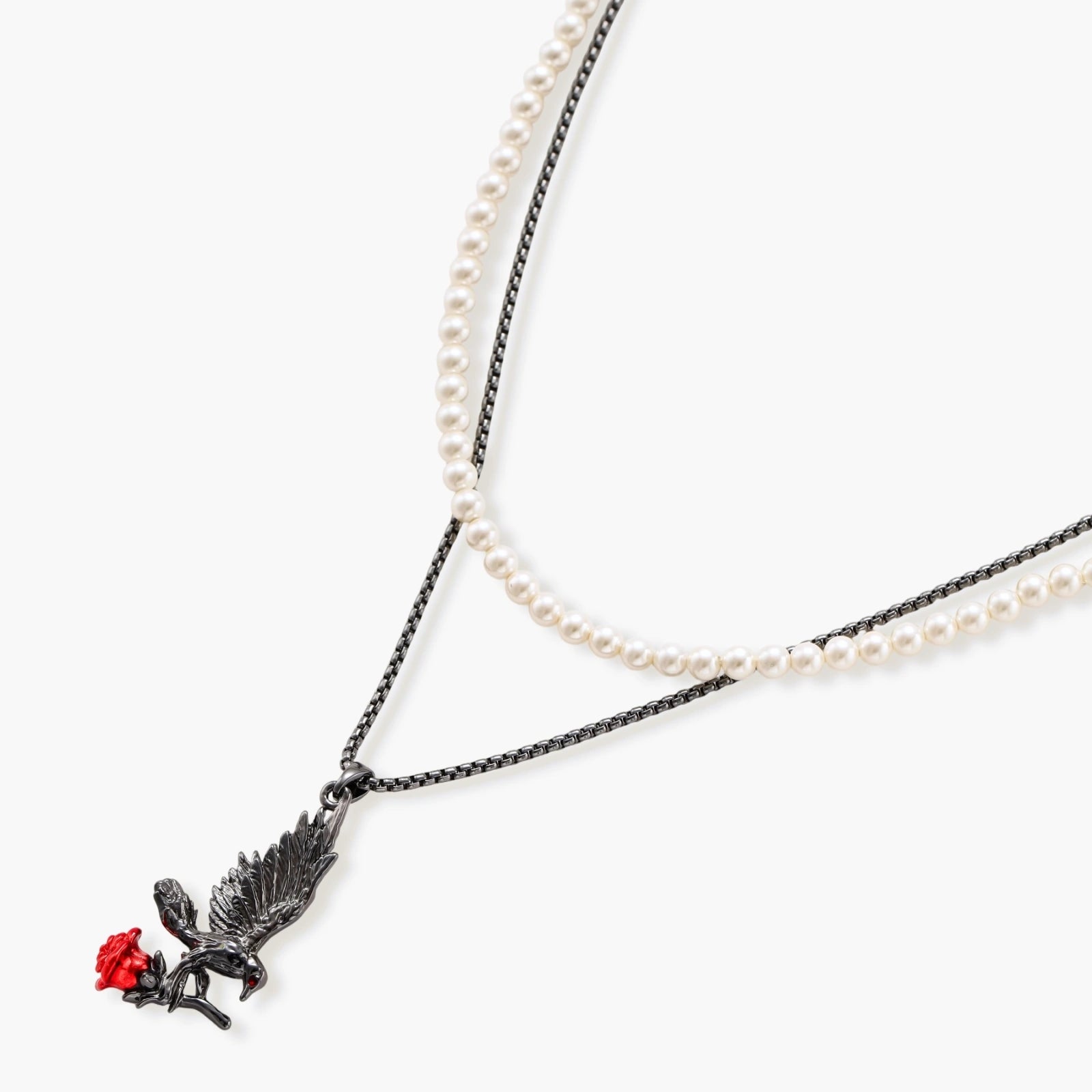 Dark gunmetal jewelry set featuring detailed raven pendants carrying red enamel roses with layered pearl and chain necklaces