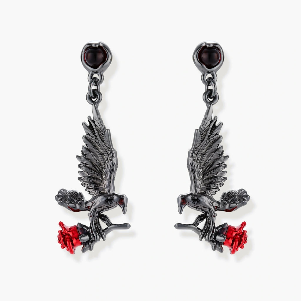 Dark gunmetal jewelry set featuring detailed raven pendants carrying red enamel roses with layered pearl and chain necklaces